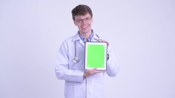 Happy Young Man Doctor Talking While Showing Digital Tablet