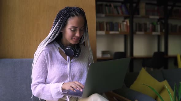 Stylish Dreadlocks Student Working on Laptop at Library or Workplace