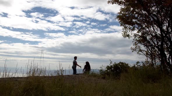 Woman standing and helping older person to stand at viewpoint