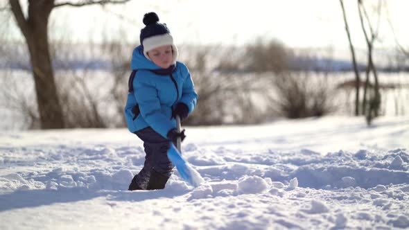 Little Boy Shoveling Snow at Winter