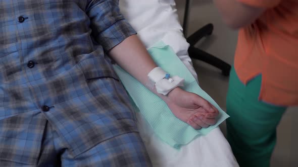 Nurse puts drip catheter in man arm get dropper medicine