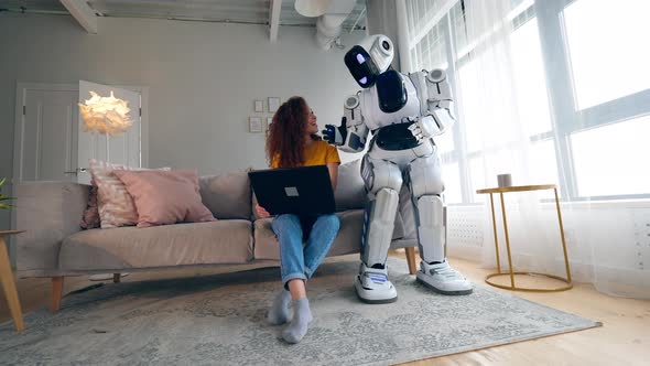 Cyborg and Human Concept. Young Woman and Cyborg Working with a Laptop.