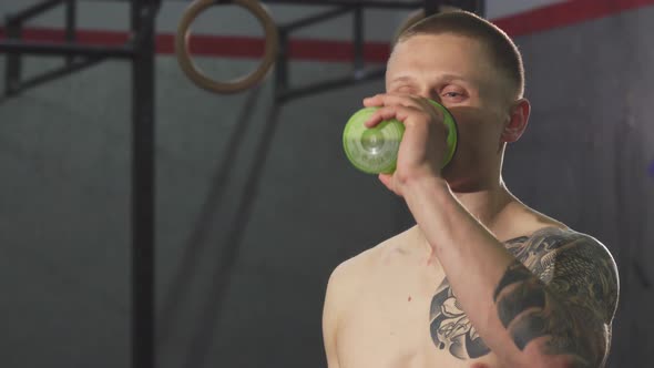 Young Cheerful Sportsman Drinking Water After a Workout