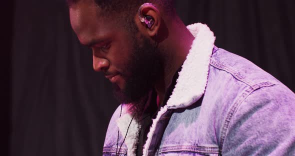 AfricanAmerican Man Dances While Playing an Electric Piano During a Concert