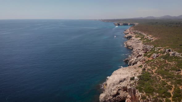 AERIAL: Fissured coastline of Mallorca Island with blue water in summer