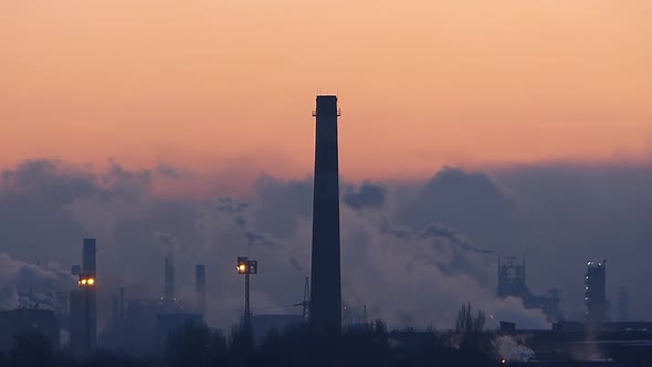 Smoky chimneys at dawn. Environmental pollution. Heavy industry pattern.