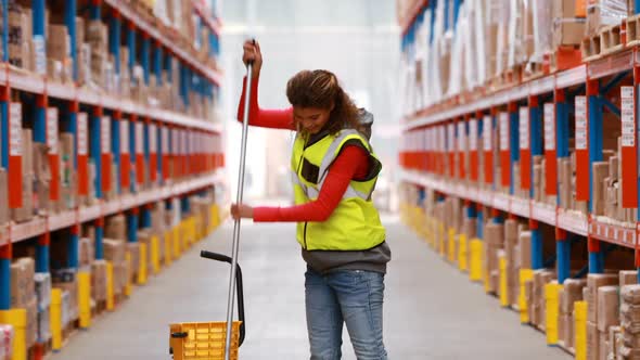 Female warehouse worker moping floor