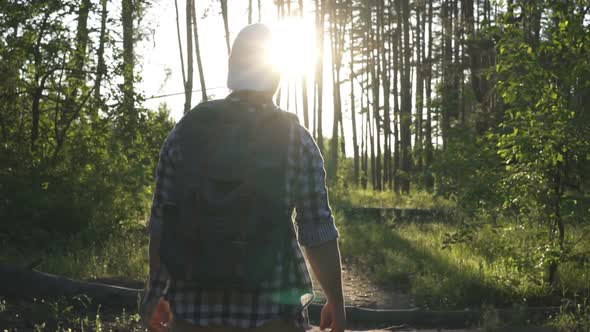 A Young Man Walks in the Woods.