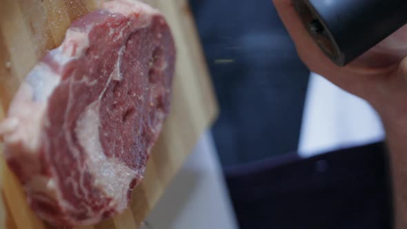 Vertical Shot Seasoning with Salt Raw Meat Steak, Close Up, Slow Motion