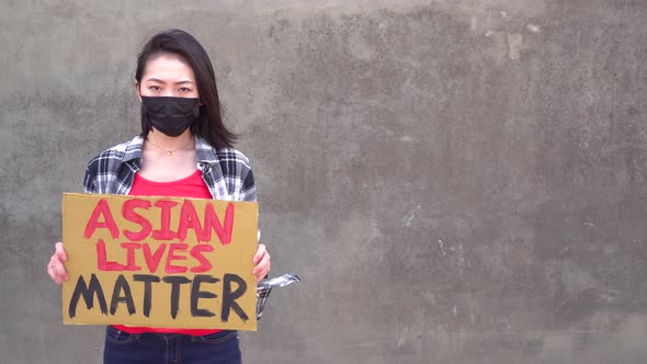 Asian woman with poster during protest against sexual harassment