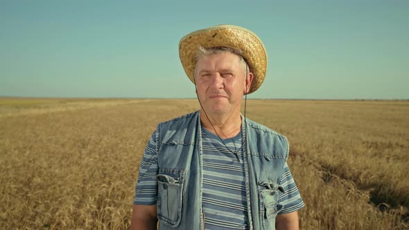 Portrait of senior farmer agronomist in barley field. Agriculture
