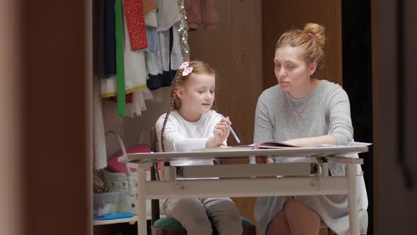 Mother With Daughter At The Desk