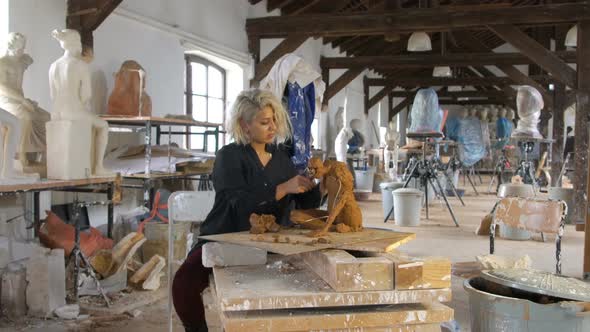 Sculptor is Sculpting a Realistic, Figurative Model in Large Studio