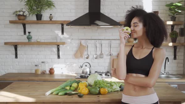 Multiracial Lady in Sportswear with Apple in Her Hands Promoting Healthy Eatting