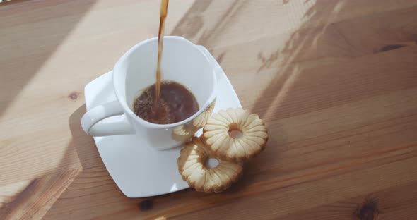 Black Coffee is Poured Into a Cup Top View