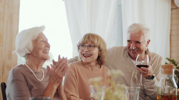 Senior Family Members Smiling and Chatting over Wine at Holiday Dinner