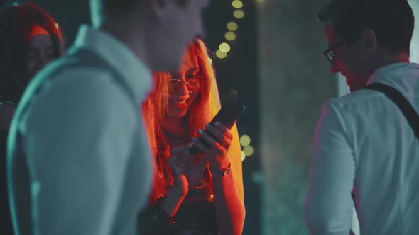 Portrait of Caucasian Blonde Girl Addicted to Phone While Dancing at Party