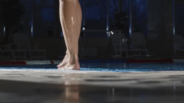 Young Woman Walks on the Edge of a Swimming Pool Then Jumping in the Water