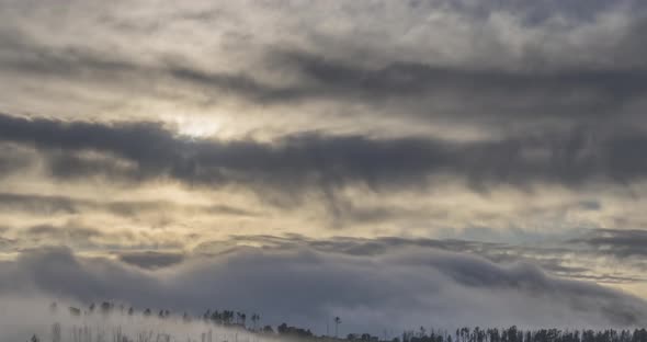 Timelapse of Evening Sun Rays Emerging Through the Cold Foggy Clouds in the Mountains