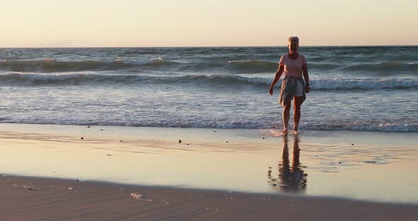 Senior woman walking on beach