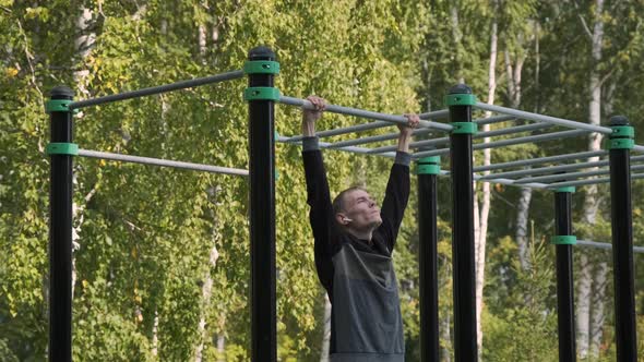 Young Man Doing Pullups on a Horizontal Bar