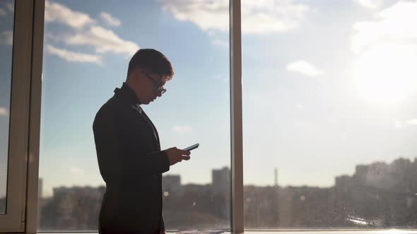 Businessman Man in a Modern Office is Negotiating on a Cell Phone Calling Partners a Business Owner