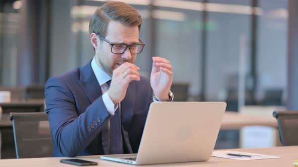 Businessman with Laptop having Headache