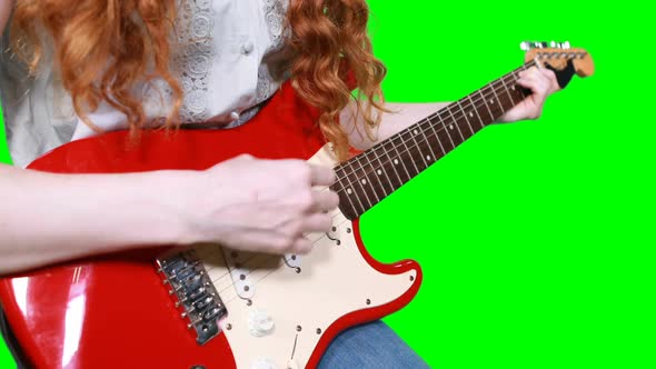 Mid section of female musician playing guitar