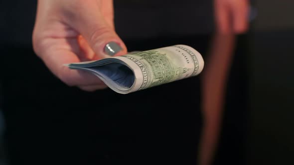 Closeup of Girl Gives a Stack of Dollars to Man