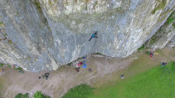 Aerial view of a man rock climbing up a mountain.