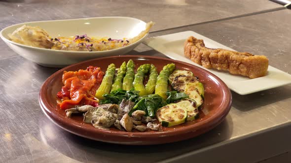 An asparagus, mushrooms, roasted peppers, zucchini, and spinach stands over a kitchen's counter by a