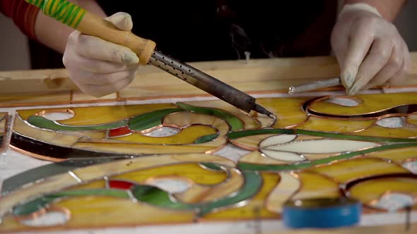 Close Shot of a Woman's Hands, Who Makes Glass Stained Glass Bright Colors