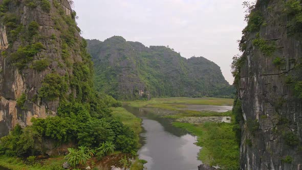 Aerial Shot of Beautiful Limestone Mountains with Passes Carved By a River in Ninh Binh Region a
