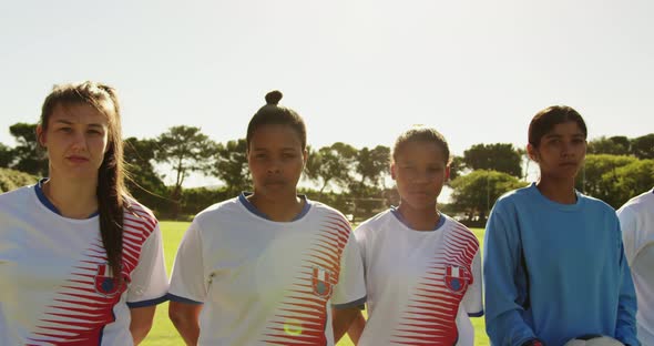 Female soccer team standing next to each other on soccer field. 4k