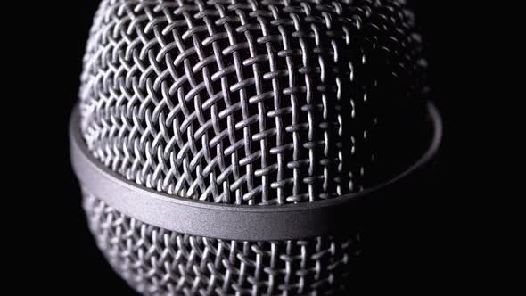 The Microphone Rotates on a Black Background. Dynamic Microphone Grid Spins Close-up