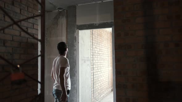 Young Guy Looks at Apartments in a New Building