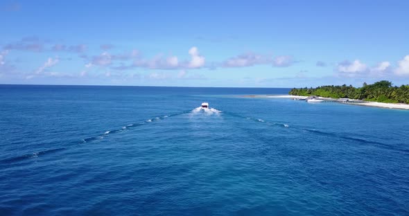 Daytime above travel shot of a sandy white paradise beach and aqua turquoise water background 