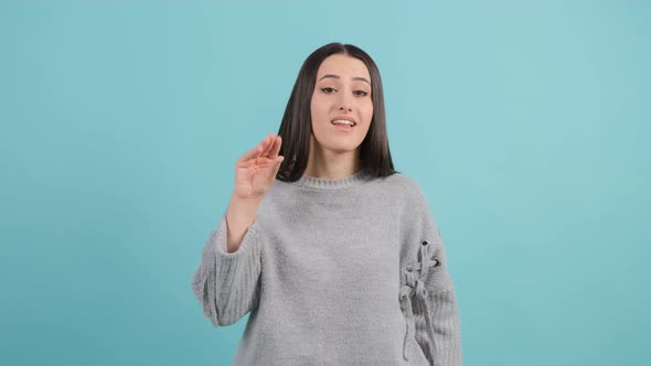 Bored Woman Make Blah Blah Gesture with Hand, Isolated on Turquoise Background.