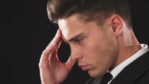 Close-up Shows the Face of a Guy Who Strokes His Forehead