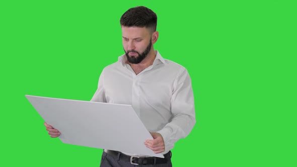 Business Man Walking and Looking at Blueprint on a Green Screen, Chroma Key.