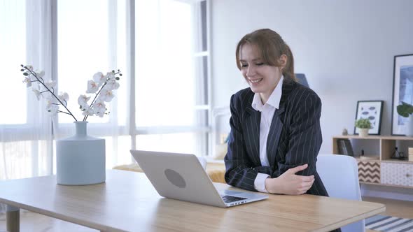 Woman Doing Online Video Chat on Laptop at Work