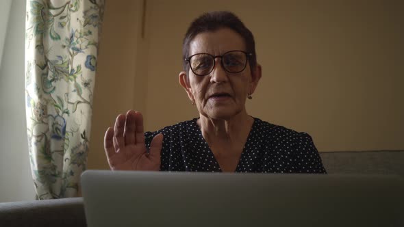 Smiling Senior Woman Sitting at Home Office Workplace Looking in Laptop