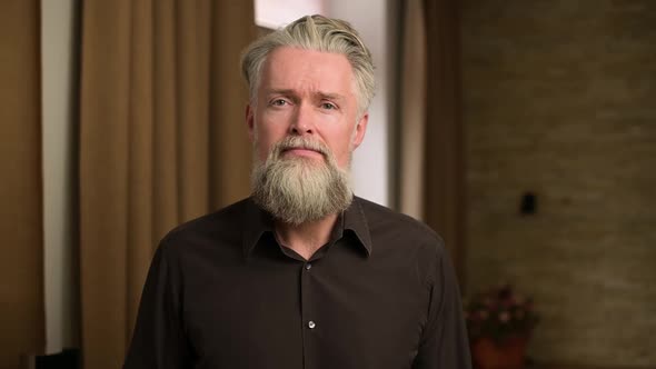 stylish adult bearded gray-haired man shows emotions of anger and frustration