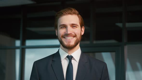 Young businessman smiling and looking at camera. Young man in a suit in the office