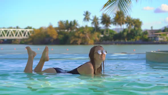 A Young Woman Relaxes in a Tropical Resort with Hot Springs, Waterfalls and Swimming Pools with Hot