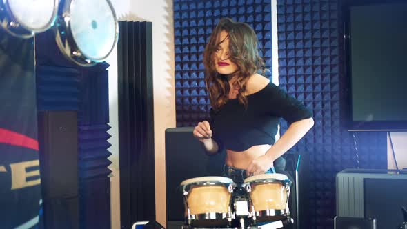 Attractive young woman plays the drums. Emotional girl drummer.