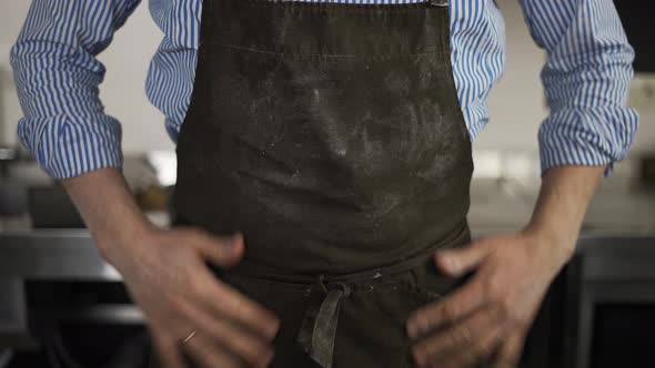 Male Baker Wipes His Hands on an Apron From Flour and Puts Hands on Hips