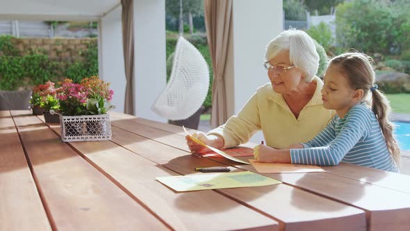 Happy grandmother and little girl drawing together 4K 4k