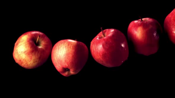 Super Slow Motion Red Apples Fall on the Water with Splashes