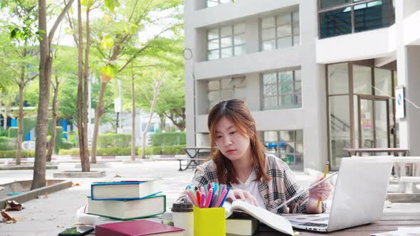 Asian student making a project, doing research for it, preparing for exam